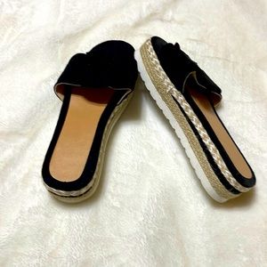 Brand new, black slip ons with black bow across foot